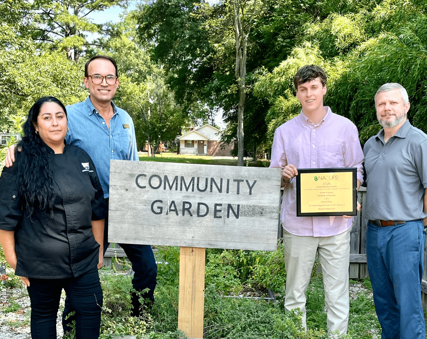 Members of the Harding University Bison Hospitality team pose with their NACUFS Award at the campus Community Garden.
